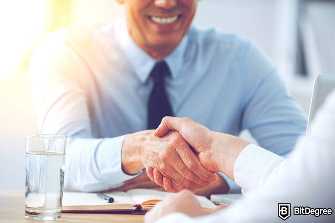 Harvard CS Course: men shaking hands after a successful job interview.